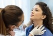 A woman is examined for thyroid disease